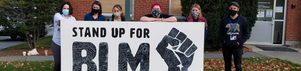 LUK CEO and youth with sign that says "Stand up for BLM" with the Black Lives Matter logo as part of LUK's DE&I efforts