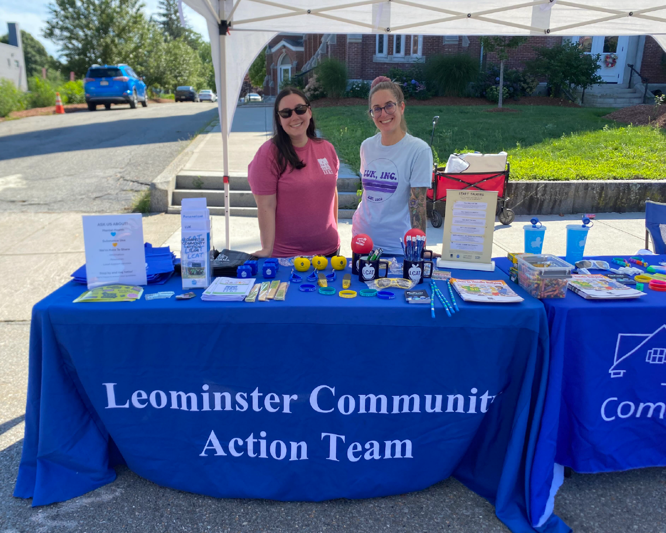 Two LCAT members stand at a resource table at a community event